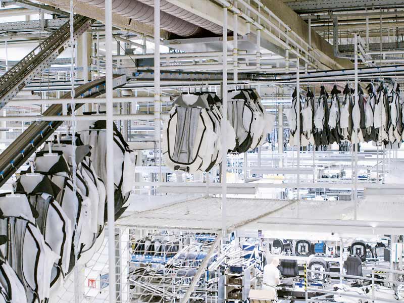 Punktuelle Belieferung der Produktion von der Decke: Pinförderer zur Beschickung von Montagearbeitsplätzen von Sitzbezügen mit Kleiderbügelklemme