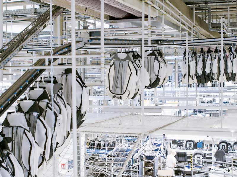 Punktuelle Belieferung der Produktion von der Decke: Pinförderer zur Beschickung von Montagearbeitsplätzen von Sitzbezügen mit Kleiderbügelklemme